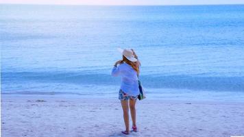 natura di viaggio donna asiatica. viaggiare rilassati. camminando sulla spiaggia. in estate foto