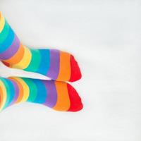 diritti lgbt. due piedi sinistri che indossano calzini con bandiera arcobaleno, con sfondo bianco foto