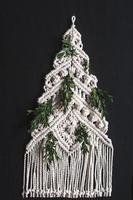 ornamento per albero di natale macramè da fili di cotone naturale bianco su sfondo nero foto