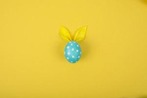 uovo con orecchie di carta a forma di coniglietto pasquale. fondo del manifesto della carta di concetto di buona pasqua foto