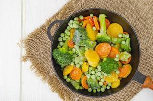 carote, broccoli e piselli surgelati in padella. foto in studio