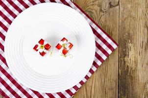 concetto di natale e capodanno. piatto bianco, tovaglia rossa. foto in studio