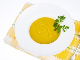 piatto bianco con zuppa di crema di zucca densa. foto in studio.