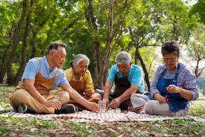 un' gruppo di asiatico anziano persone godere pittura cactus pentole e ricreativo attività o terapia all'aperto insieme a un anziano assistenza sanitaria centro, stile di vita concetti di anzianità foto