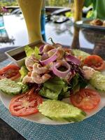 Immagine in mostra un' vivace gamberetto insalata con fresco verdure e condimento su un' soleggiato giorno, ideale per salutare stile di vita e cibo menu foto