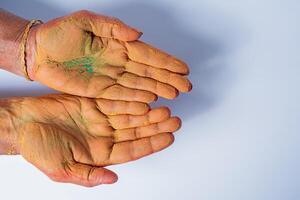 avvicinamento di umano mano con holi polvere nel mano isolato su bianca sfondo. foto