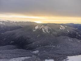 Visualizza di il inverno tramonto e innevato montagne nel sochi foto