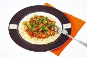 spaghetti con verdure stufate e olive verdi. foto in studio