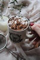 caldo cacao con marshmallow nel un' bianca ceramica boccale circondato di bevanda preparazione ingredienti. accogliente inverno composizione foto