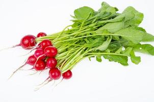 mazzo di giovane ravanello fresco rosso con le foglie verdi isolate su fondo bianco, menu vegetariano di dieta. foto in studio