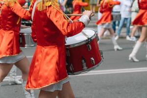 giovane ragazze batterista nel rosso Vintage ▾ uniforme a il parata. strada prestazione di festivo marzo di batteristi ragazze nel rosso costumi su città strada foto