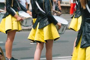 avvicinamento di mani di femmina batteristi nel giallo nero Vintage ▾ uniforme a parata foto