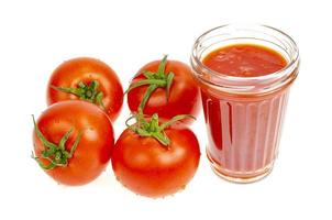 bicchiere di succo di pomodoro naturale, pomodori rossi freschi su sfondo bianco. foto