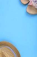scarpe estive e un cappello di paglia su sfondo blu. sfondo di concetto estivo con plauso per il testo foto