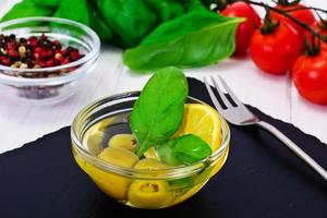 olive verdi con olio e basilico foto