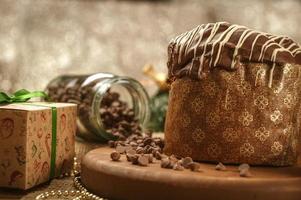 panettone al cioccolato su tavola di legno con addobbi natalizi foto