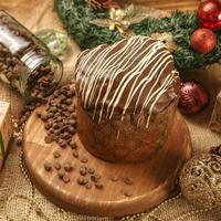 panettone al cioccolato su tavola di legno con addobbi natalizi foto