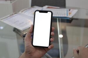 mano Tenere smartphone nel ufficio, utilizzando Telefono foto