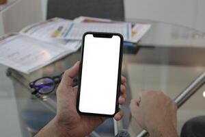 mano Tenere smartphone nel ufficio, utilizzando Telefono foto