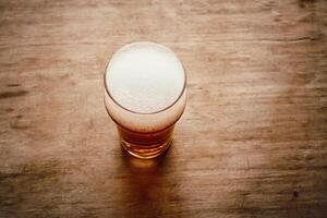 un' bicchiere con birra su il di legno sfondo foto