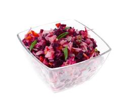 dieta vegetariana insalata di verdure con barbabietole in un'insalatiera di vetro su sfondo bianco.