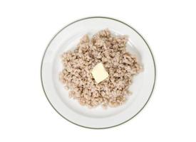 porridge, orzo perlato bollito sul piatto su sfondo bianco