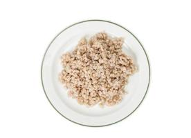 porridge, orzo perlato bollito sul piatto su sfondo bianco
