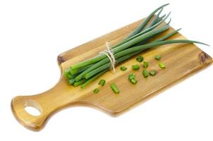 tagliere da cucina in legno per affettare cipolle verdi fresche. foto