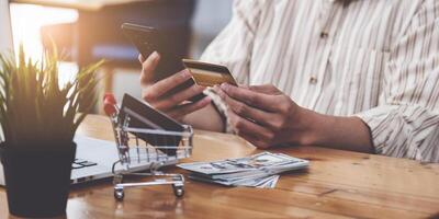 un' uomo Tenere credito carta e digitando nel credito carta numero smartphone per in linea shopping e pagamento fa un' Acquista su il Internet. foto