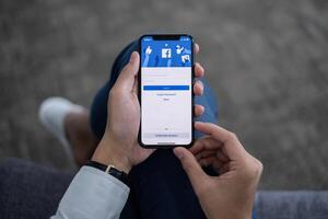 chiang Mai Tailandia. giugno 10, 2021. un' uomo detiene i phone con Facebook applicazione su il schermo. Facebook è un' condivisione di foto App per smartphone.