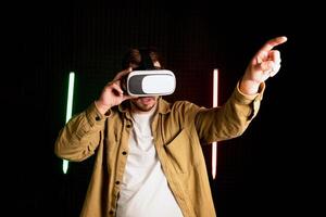 virtuale la realtà bicchiere vr. giovane uomo nel digitale bicchieri per 3d virtuale la realtà gioco su buio sfondo. Augmented realtà, gioco, futuro tecnologia concetto. vr foto