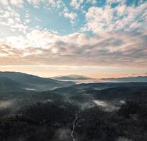 volando sopra le nuvole alba e nebbia foto