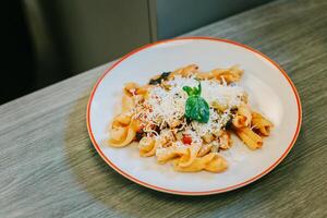 un' piatto di tradizionale italiano piatto pasta per pranzo nel un' bar. foto