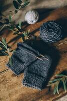 mano a maglia calzino con aghi e grigio filato palla su buio di legno sfondo. concetto per fatto a mano e hygge lento vita. foto