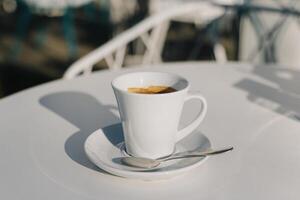 tazza di nero caffè su un' tavolo nel un' strada bar. foto