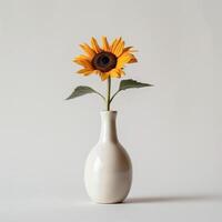 un' minimalista ceramica vaso detiene un' singolo girasole. foto