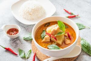 tradizionale tailandese pollo rosso curry con fresco verdura e erba nel ciotola su tavolo, tailandese cibo concetto con riso foto