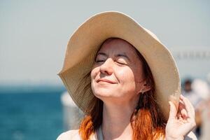 un' dai capelli rossi donna gode un' sereno momento, occhi Chiuso, con il sole su sua viso foto