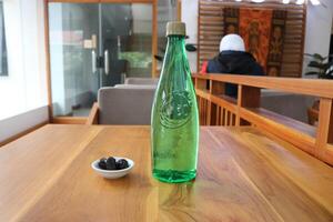 bottiglia di minerale acqua con 3 date, Kurma su il tavolo foto