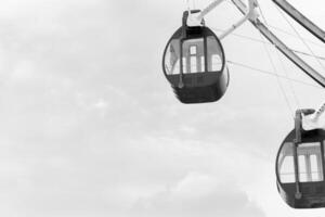 vicino su nero e bianca Ferris ruota su divertimento parco con nube sfondo foto