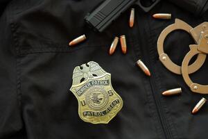 kiev, Ucraina - marzo 9, 2024 noi confine pattuglia agente distintivo su nero giacca uniforme con pistola, proiettili e manette foto