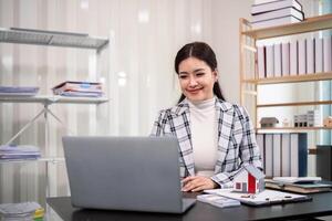 vero tenuta agente Lavorando con il computer portatile a tavolo nel ufficio foto