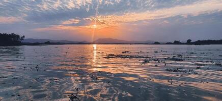 esotico tramonto con luce del sole splendente su acque di kaptai lago foto