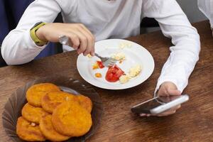 un irriconoscibile uomo mangia cibo a partire dal un' piatto. foto