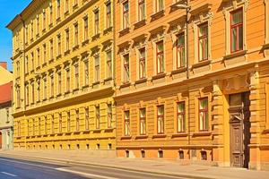 una classica facciata di un vecchio edificio dipinta nei colori giallo e arancione. edificio residenziale su una strada vuota foto