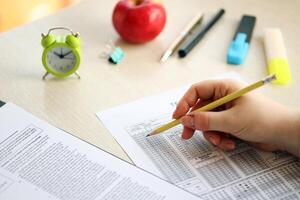 femmina alunno mani analisi nel esercizio e assunzione riempire nel esame carta foglio con matita a scuola test foto