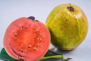 guaiava isolato. collezione di rosso incarnato guaiava frutta con giallastro verde pelle su un' foglia isolato su un' bianca sfondo. foto