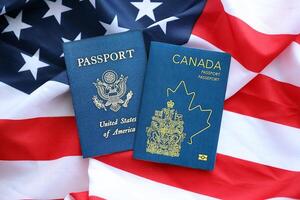 passaporto di Canada con noi passaporto su unito stati di America piegato bandiera foto