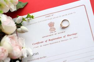 indiano certificato di registrazione di matrimonio vuoto documento e nozze squillare su tavolo foto