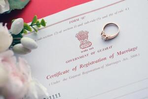 indiano certificato di registrazione di matrimonio vuoto documento e nozze squillare su tavolo foto